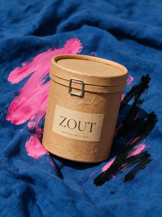 Kraftpapieren koker tussen roze verfstreken op blauw